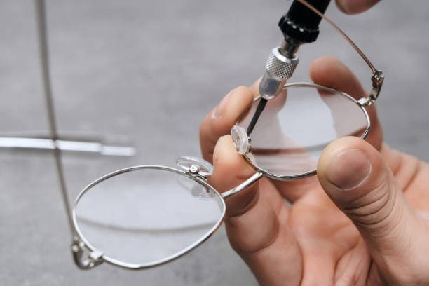 Optician performing precision frame repair